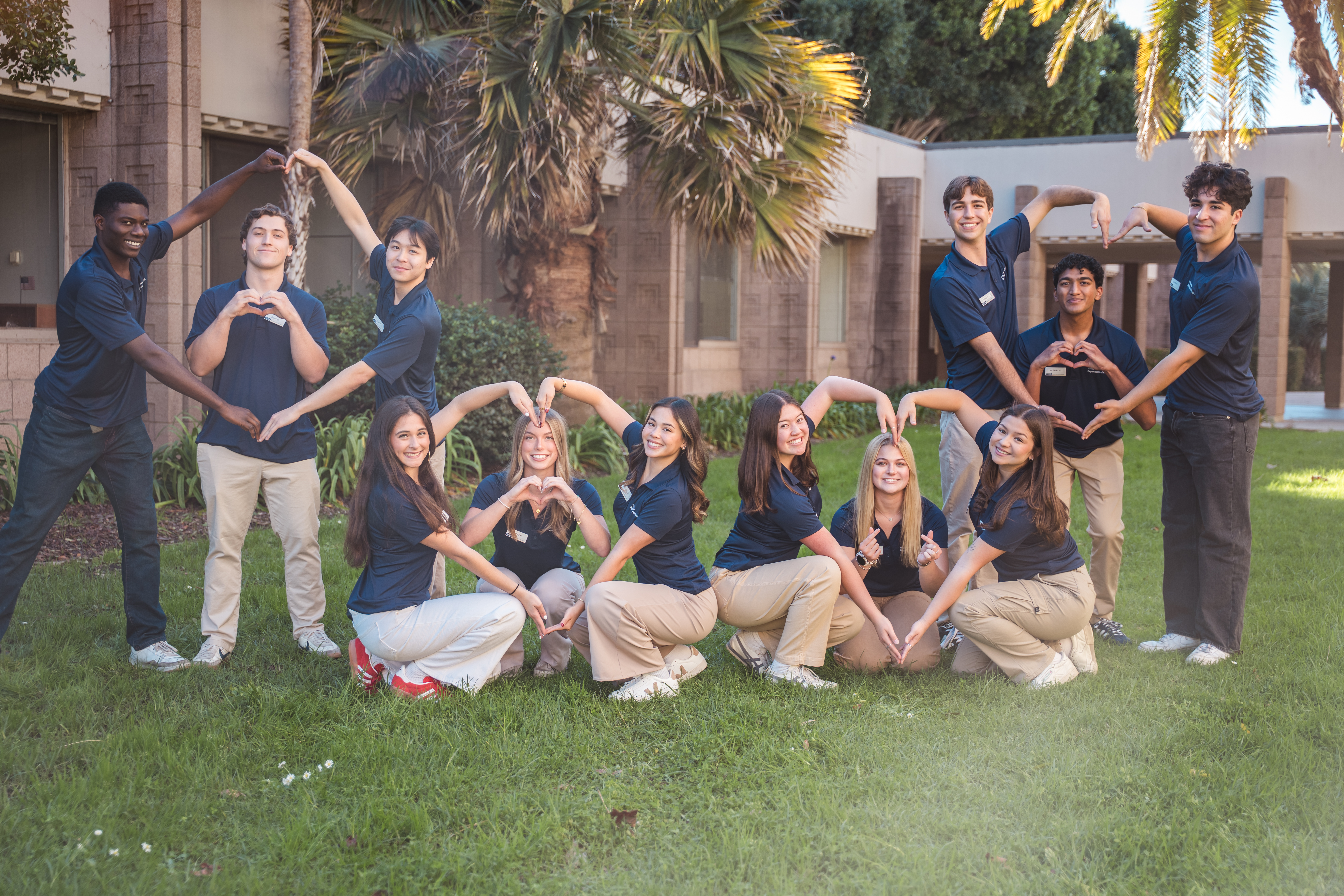Group of Athletic Training staff making heart shapes with their arms.