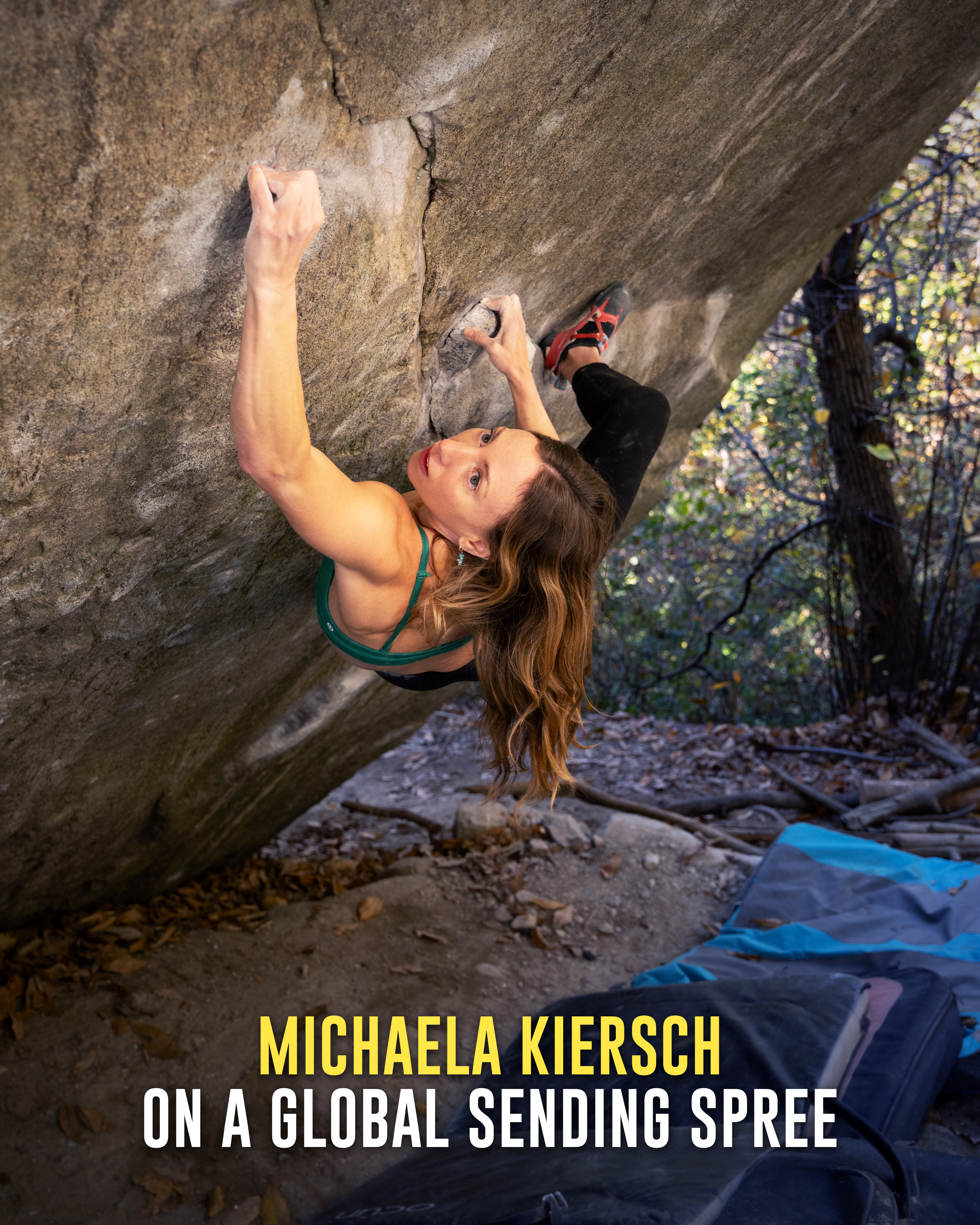 Michaela Kiersch: An image of Michaela climbing on two crimps with a heel hook. There are crashpads beneath an overhanging climb
